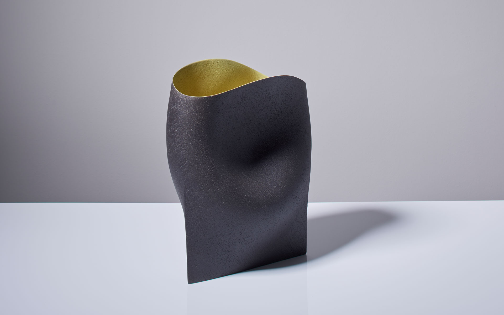 Black vessel with yellow interior